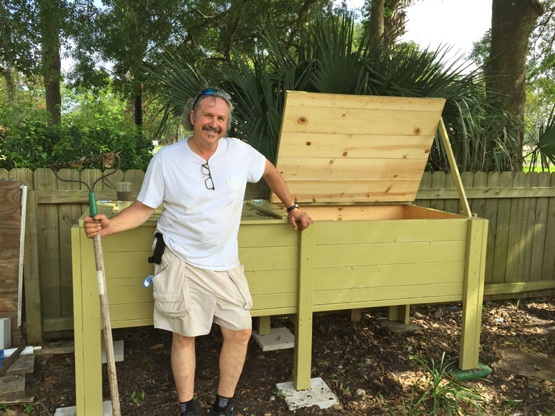 The After-Fifty Adventure Man standing beside his worm composting box. A Gentleman Farmer.